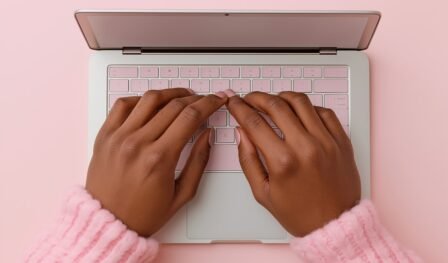 SEO pagina optimalisatie Een roze achtergrond, een roze toetsenbord en een roze trui - op de foto zie je iemand typen achter een laptop. Deze afbeelding wordt gebruikt voor de blog van Keller SEO over pagina optimalisatie.